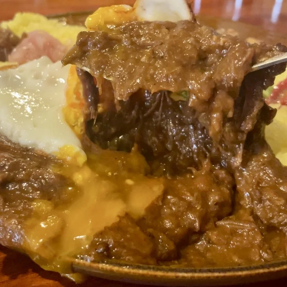 煮込まれた肉と目玉焼き