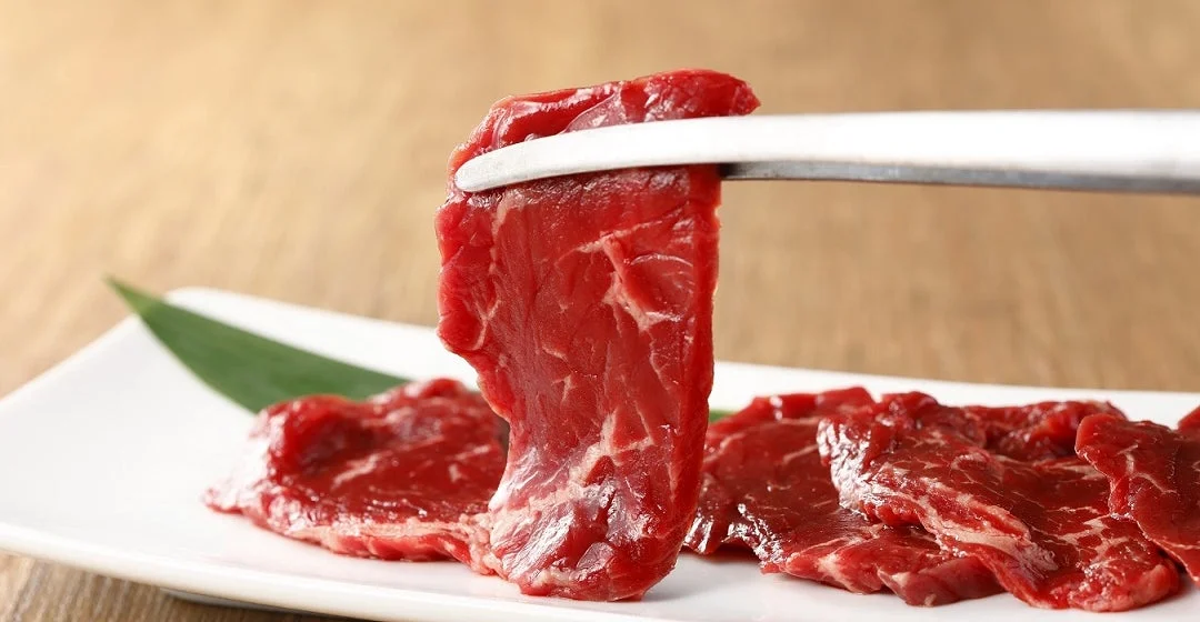 白い皿に盛られた新鮮な生牛肉のスライス