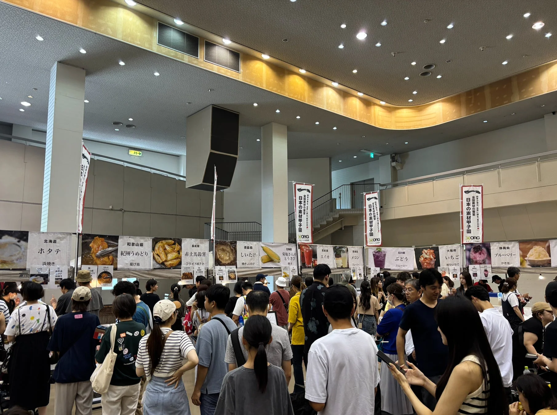 多くの人々で賑わう屋内の食のイベント会場