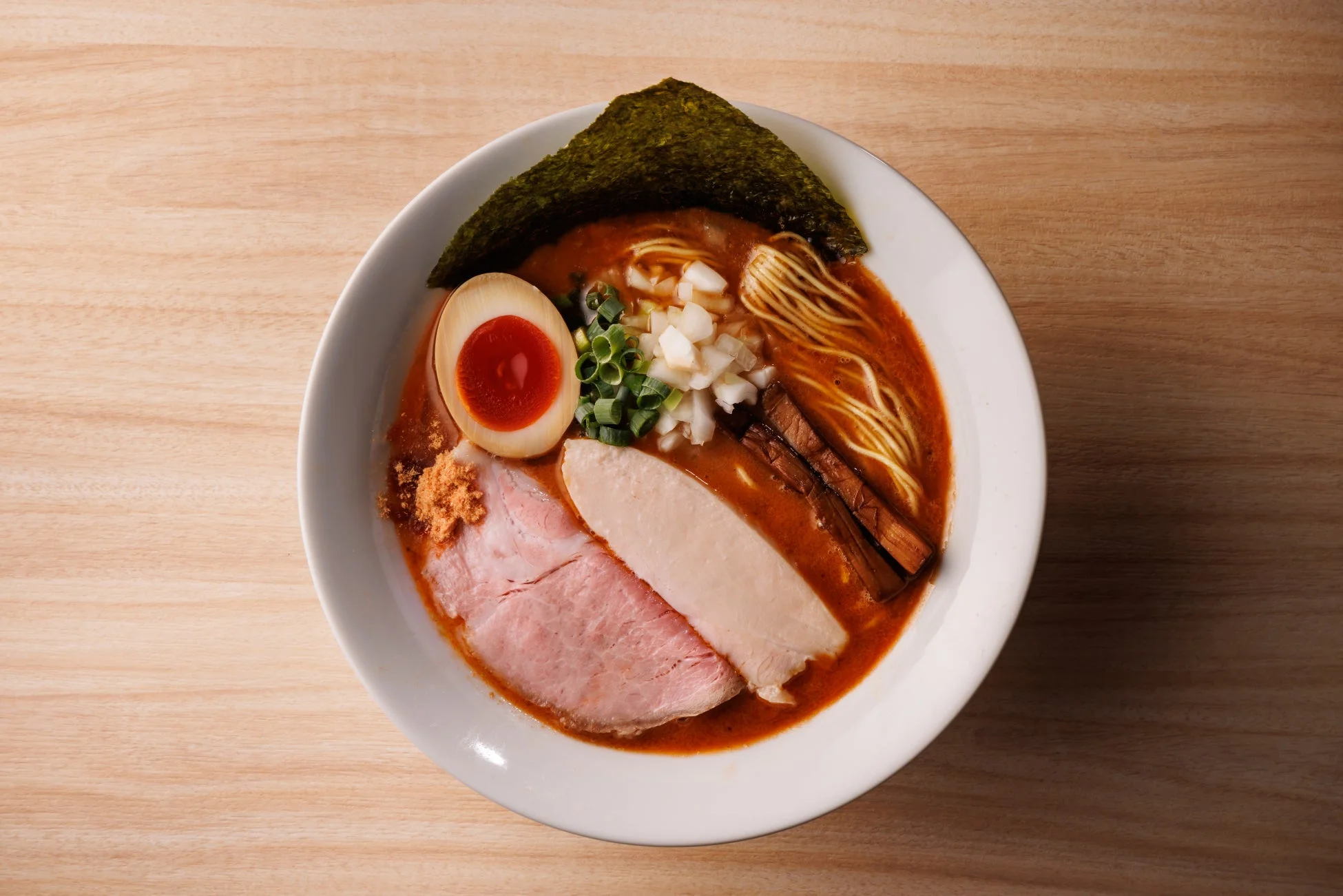 赤みがかった濃厚スープのラーメン