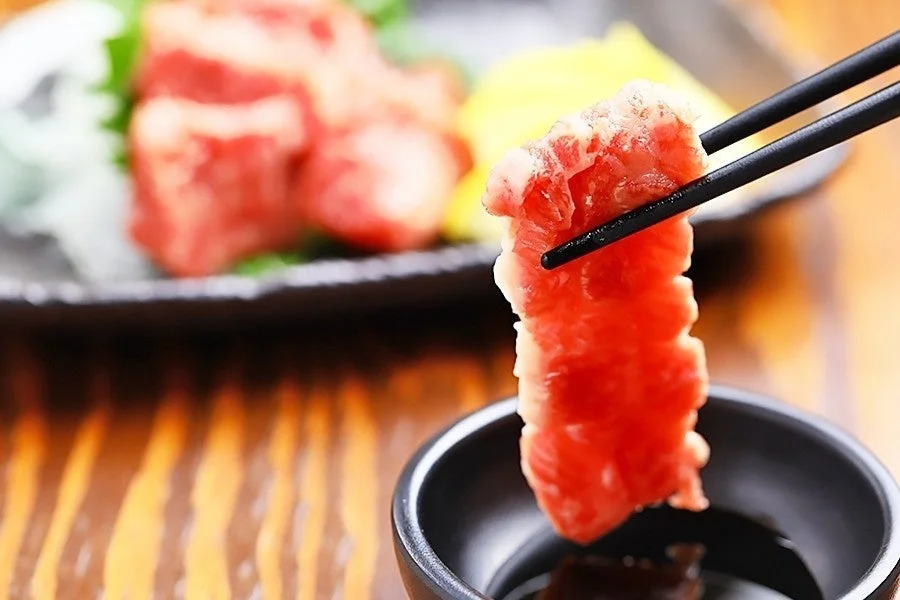 箸で掴まれた新鮮な赤身肉