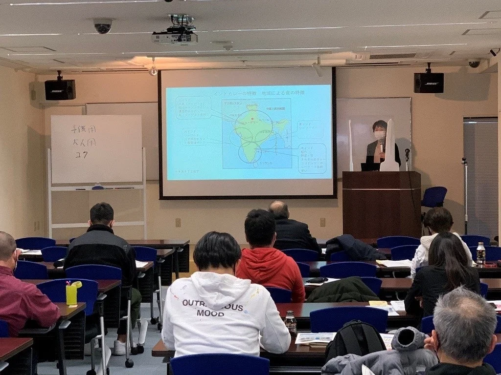 会議室でインドカレーの地域による特徴に関する講義が行われている