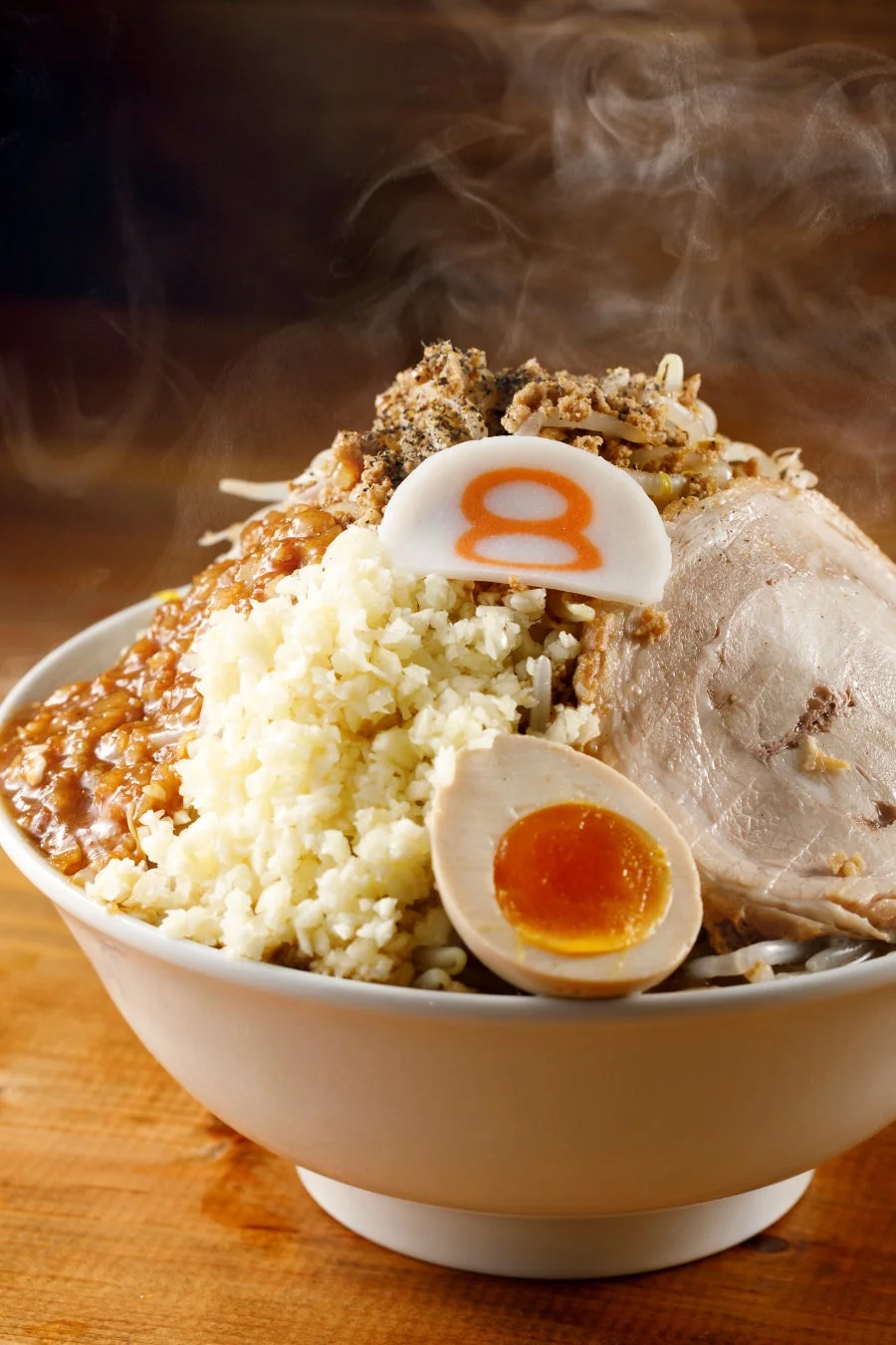 湯気が立つ熱々のラーメンまたはまぜそばのクローズアップ