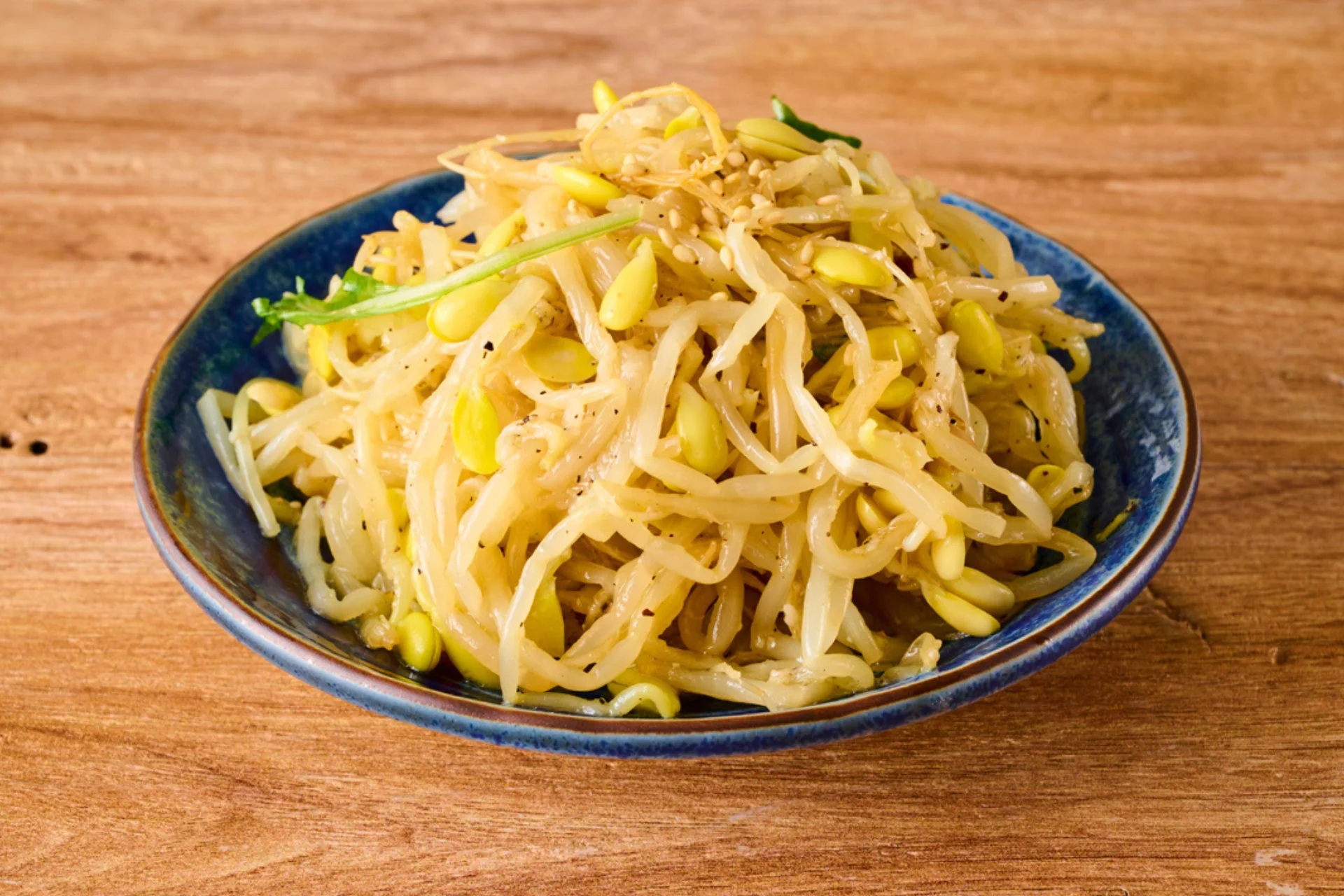 青い器に盛られたもやしと大豆の和え物