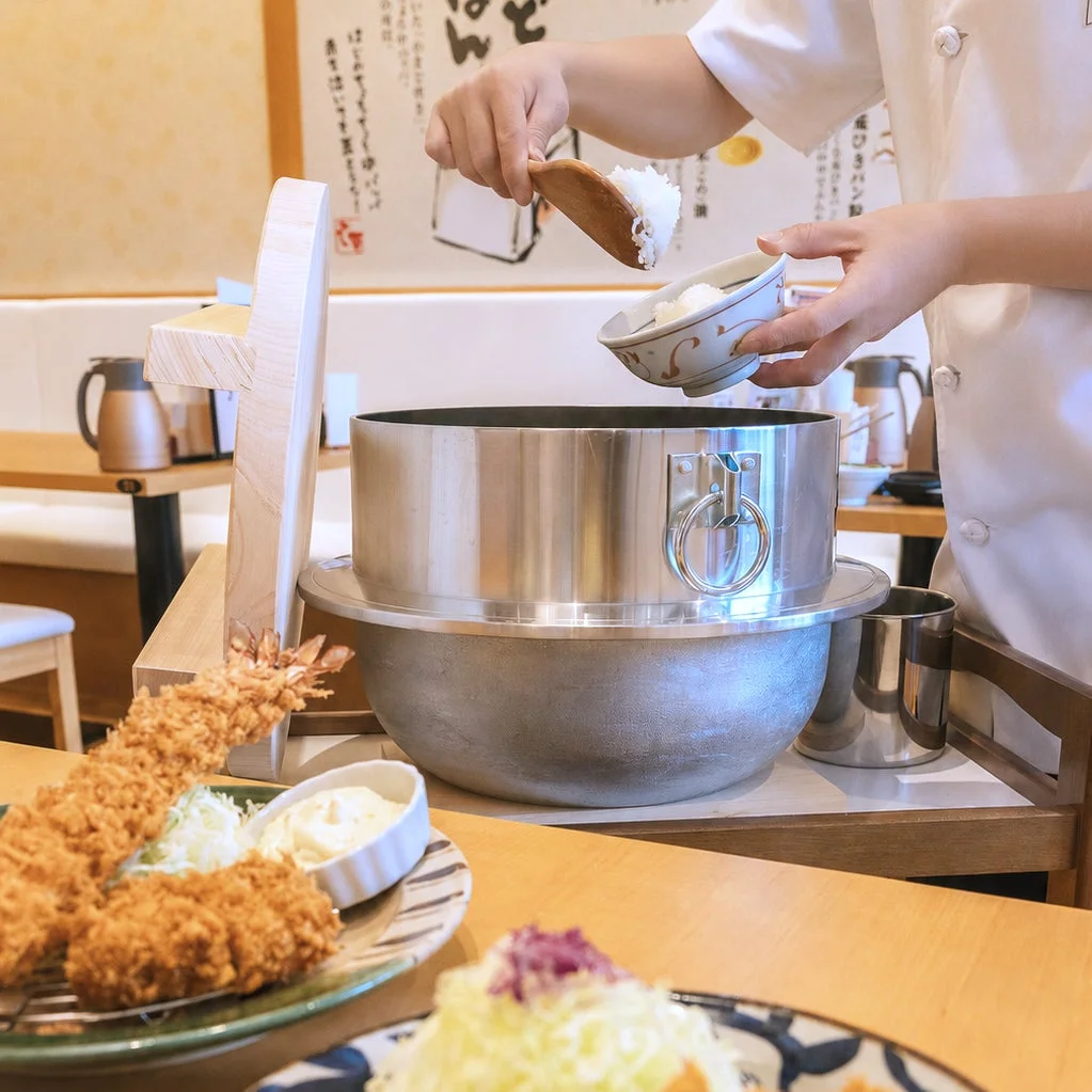 釜から炊きたてのご飯をよそる店員