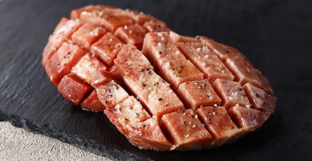黒い石板の上に置かれた下味をつけられた牛肉の塊