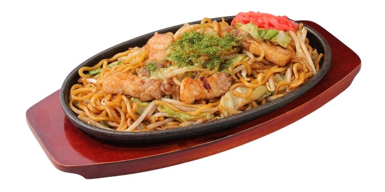 熱々の鉄板に盛られた豚肉と野菜たっぷりの焼きそば