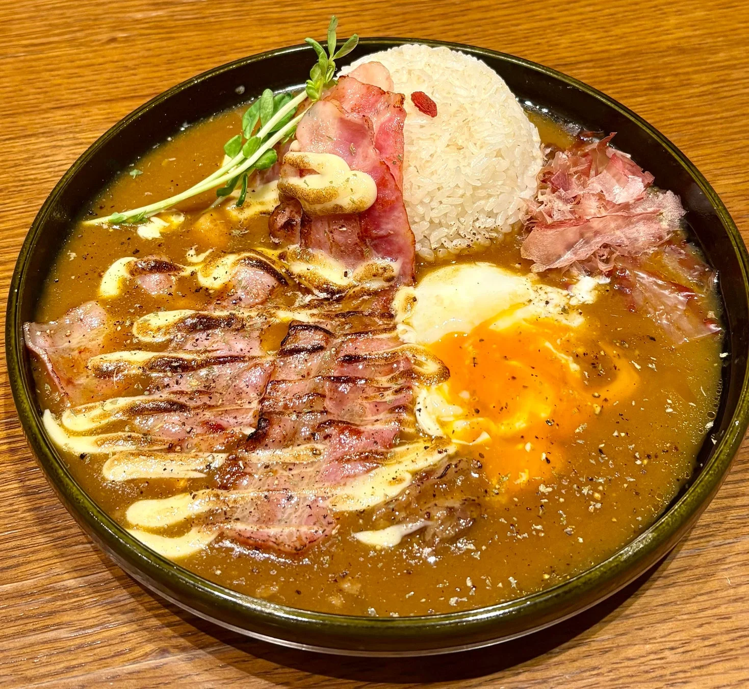 ベーコンと目玉焼きが大胆にトッピングされたカレーライス