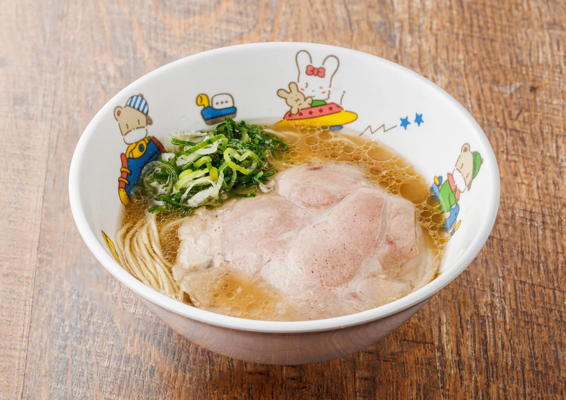 可愛らしいキャラクターが描かれた白いどんぶりに入ったラーメン