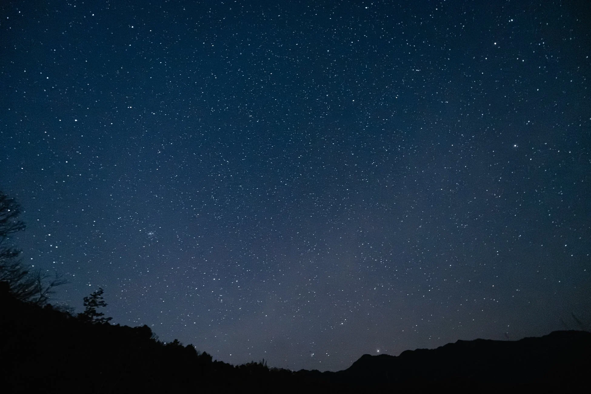 星が輝く夜空と山々のシルエット