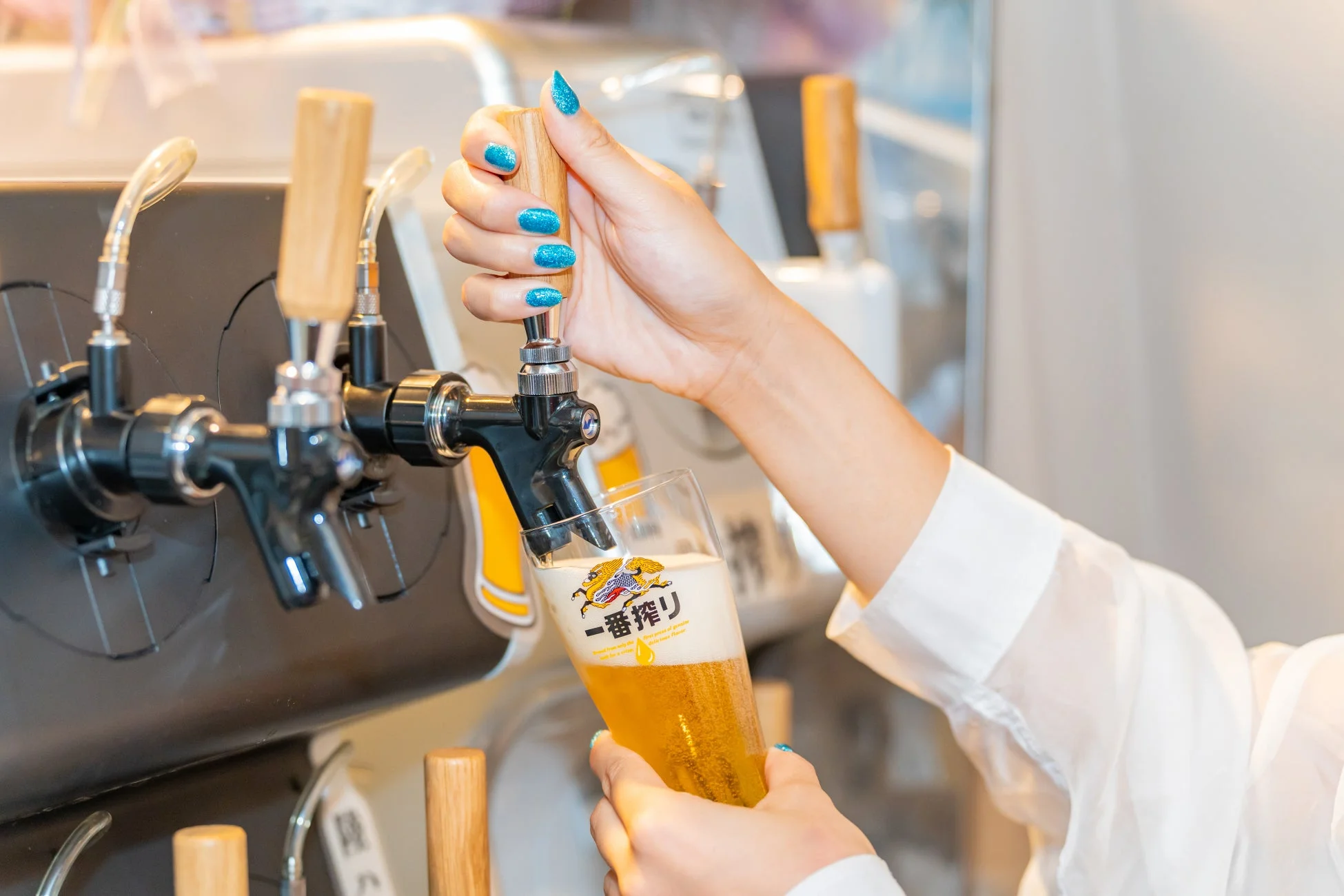 ビールサーバーからグラスにビールを注ぐ手
