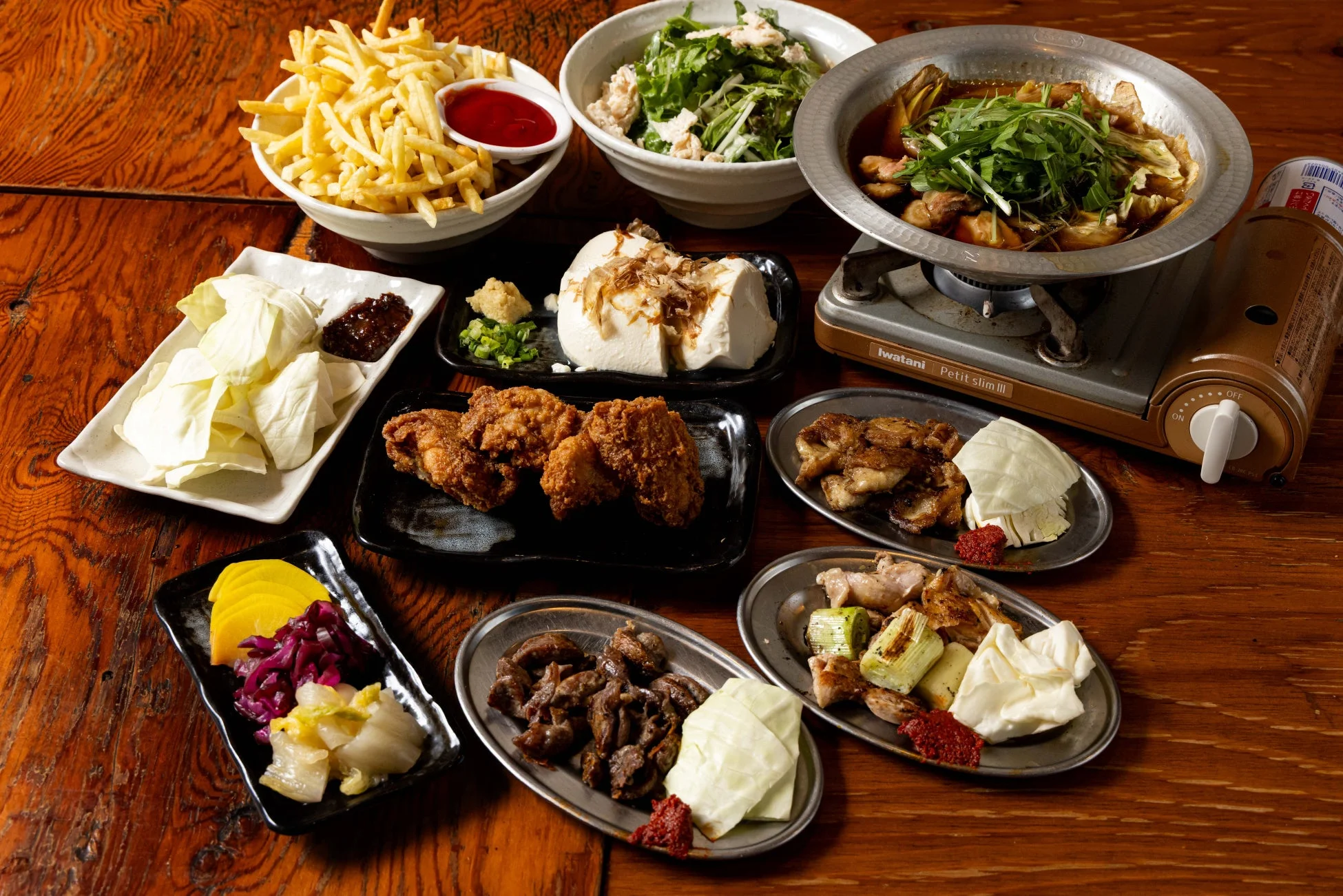 様々な種類の居酒屋料理が並べられた賑やかな食卓