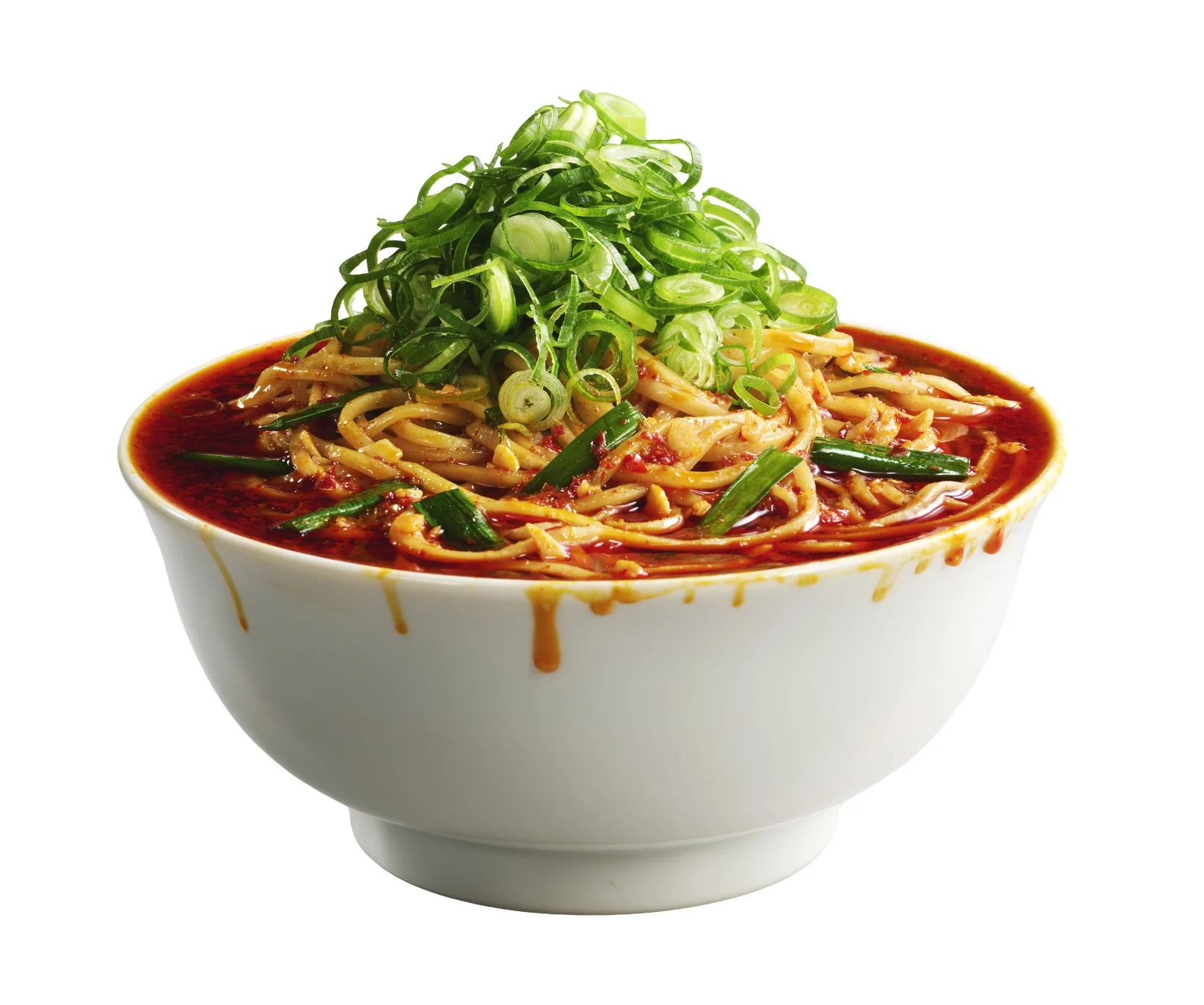 白い器に盛られた、たっぷりの刻みネギが特徴的な辛そうな麺料理です。赤みがかった濃厚なタレ（またはスープ）に麺が絡み、食欲をそそります。器の縁からはタレが垂れています。